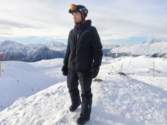 Snowboarder poseert in Colmar outfit op de piste in Zwitserland