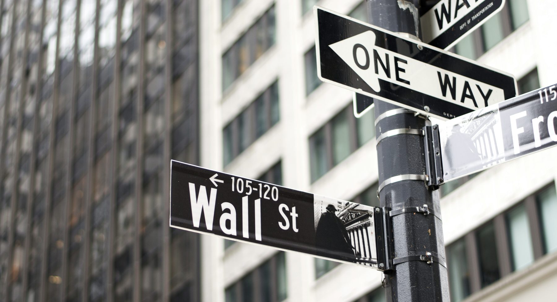 Een wegwijzer in New York die naar Wall Street wijst.