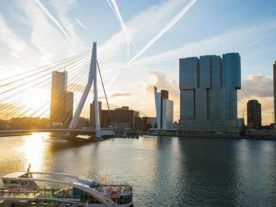 Een uitzicht op de Erasmusbrug in Rotterdam met op de voorgrond een boot.